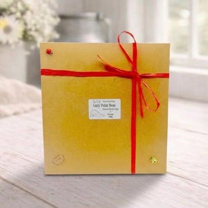 huge highly detailed polar bear shaped vegan bar soap, handmade and resting on a rustic wooden table with floral backdrop - ideal sustainable gift idea for animal lovers.