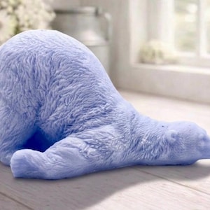 huge highly detailed polar bear shaped vegan bar soap, handmade and resting on a rustic wooden table with floral backdrop - ideal sustainable gift idea for animal lovers.