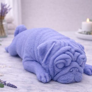 handmade vegan soap in the shape of a realistic sleeping pug dog lying flat, showing detailed wrinkles and fur texture, displayed in a spa-like setting with a candle and lavender.