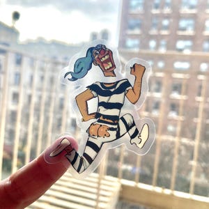 May include: A clear sticker of a cartoon character running. The character is wearing a black and white striped outfit and has blue hair. The character is smiling and has a red nose.