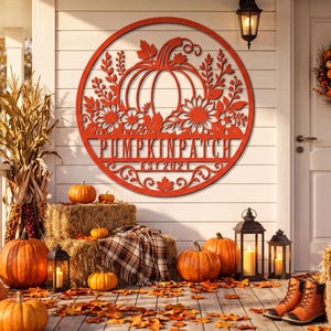 May include: A circular orange metal wall sign featuring a cutout design of a large pumpkin, sunflowers, and foliage. The text PUMPKIN PATCH and EST 2021 is centered horizontally across the middle of the circular frame in a bold, sans-serif font.