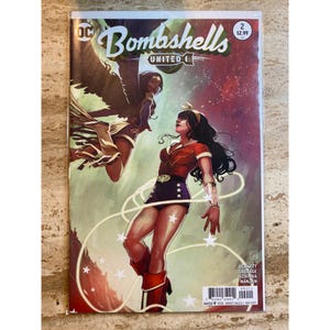 May include: A comic book cover for "Bombshells United" features two female superheroes. One is in a red and blue outfit with stars, the other has wings. The cover has the DC Comics logo and the price.