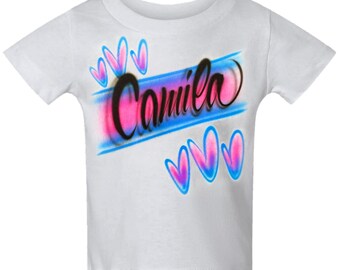 Líneas de escritura con aerógrafo y diseño de nombre personalizado con corazones.