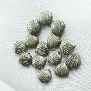 May include: A collection of 14 silver-toned pyrite gemstone cabochons, each cut in a heart shape with a scalloped edge. The cabochons are arranged in a loose cluster on a white surface.