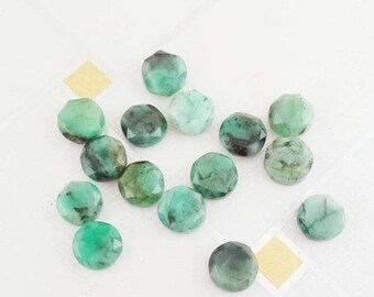 May include: A collection of 15 faceted emerald green gemstones, each with a unique pattern and shade of green.