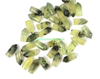 May include: A collection of 20 green and black crystal points. The points are approximately 1 inch long and have a pointed tip. The crystals are translucent and have a natural, rough texture.