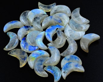 May include: A collection of 20 iridescent moonstone crescent moon shaped crystals. The crystals are a milky white color with blue and green iridescent flashes.
