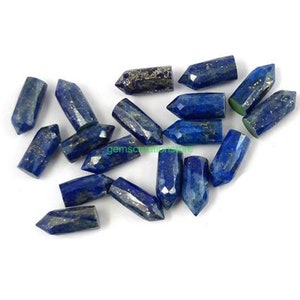May include: A collection of 17 blue lapis lazuli gemstone points, each with a pointed tip and a faceted, hexagonal shape. The points are approximately 1 inch in length and have a dark blue color with flecks of gold pyrite.