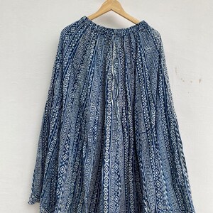 Peut inclure: Jupe longue à motifs bleus et blancs suspendue à un cintre en bois. Le motif géométrique se répète en indigo et blanc. Le tissu léger semble idéal pour les températures chaudes. La jupe mesure environ 90 cm de long.