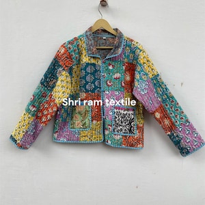 May include: A patchwork jacket with a vibrant mix of colors and patterns. The jacket features a collared neckline, long sleeves, and a button-up front. The text "Shri ram textile" is visible on the jacket.