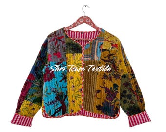 May include: A patchwork jacket with a variety of floral and patterned fabrics in shades of blue, yellow, and green. The jacket has long sleeves and a red and white striped trim. The text "Shri Ram Textile" is visible on the front.