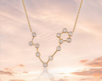 May include: A gold necklace with a diamond constellation pendant in the shape of the zodiac sign Pisces.