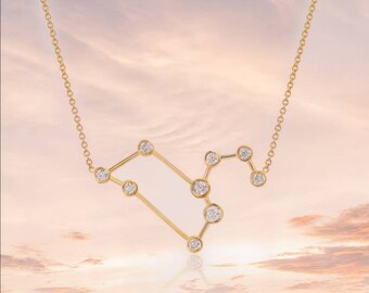 May include: A gold necklace with a constellation pendant featuring small diamonds. The pendant is shaped like the constellation Leo.