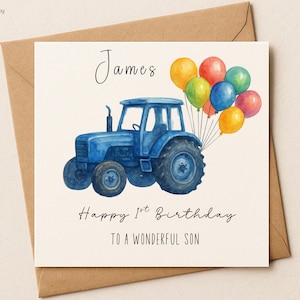 Puede incluir: Tarjeta de cumpleaños con un tractor azul y globos de colores. La tarjeta dice "James Happy 1st Birthday TO A WONDERFUL SON". La tarjeta está en un sobre marrón. Diseñado por The Party Play Company.