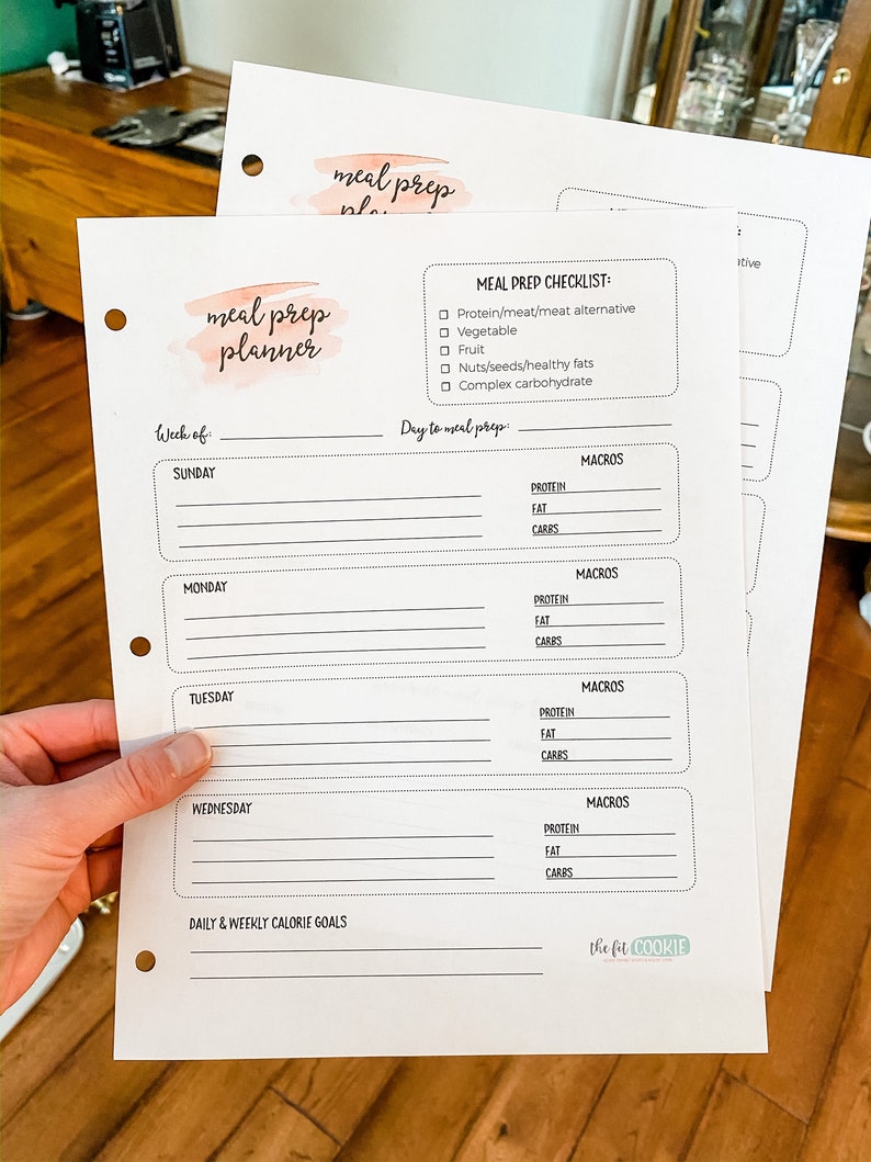 May include: A printable meal prep planner with a watercolor design. The planner includes a checklist for meal prep, a section for daily and weekly calorie goals, and a section for tracking macros for each day of the week. The planner is titled "meal prep planner" and "The Fit Cookie" is printed at the bottom.