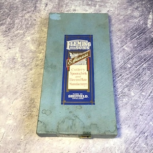 以下が含まれることがあります： 金色の留め金が付いた、ヴィンテージの青いカトラリーボックス。ボックスには「FLEMING AND SONS Effaness Cutlery Spoon & Fork and Electro Plate Manufacturery MADE IN SHEFFIELD. ENGLAND.」と書かれたラベルが付いています。