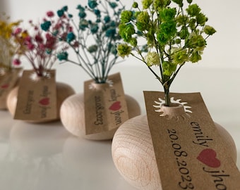 May include: Five small wooden vases with dried flowers in various colors, each with a personalized tag with the names "emily & jhon" and the date "20.08.2023".