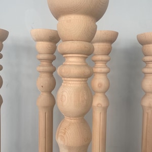 May include: Five unfinished wooden balusters with a turned design. The balusters are all the same size and shape, and they have a smooth, polished finish.