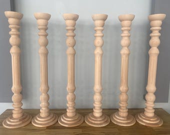 May include: Six wooden candle holders with a fluted design and a round base. The candle holders are all the same size and are arranged in a row.
