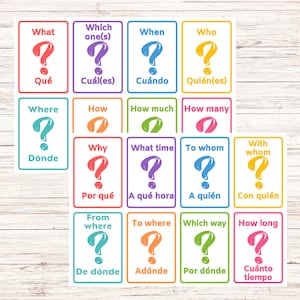 May include: Set of 16 question cards with colorful borders and question marks. The cards feature common question words in English and Spanish, such as "What", "When", "Where", "Why", "Who", "How", "Which", and "How much".