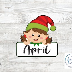 May include: A red and green elf with a brown ponytail holding a white sign that says "April".