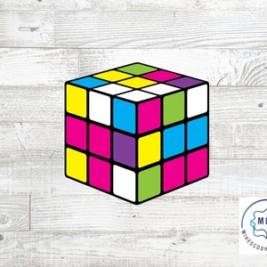 May include: A colorful 3D cube cookie cutter with a retro design. The cube is made up of nine squares, each with a different color: yellow, pink, green, blue, purple, and white.