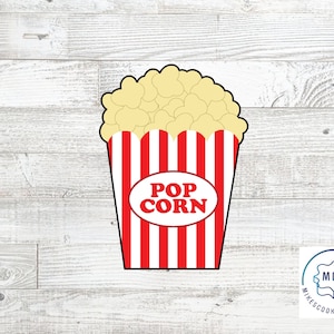 Può includere: Tagliapasta a forma di secchiello per popcorn a strisce rosse e bianche con la parola "POPCORN" in un cerchio bianco. Il tagliapasta è progettato per creare una forma di secchiello per popcorn.