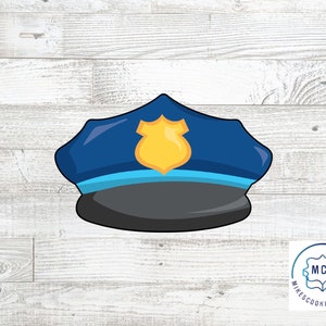 May include: A blue and black police officer hat cookie cutter with a gold badge. The cookie cutter is on a white wood background.  Mike's Cookie Cutters logo is in the bottom right corner.
