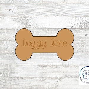 May include: Brown cookie cutter shaped like a dog bone with the words "Doggy Bone" written on it.