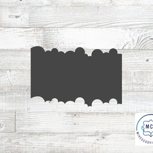 May include: A black cookie cutter shaped like a cloud with a scalloped edge. The cookie cutter is on a white wood background. The text "MCC Mike's Cookie Cutters" is in a circle in the lower right corner of the image.