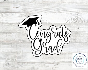 May include: Black and white cookie cutter with the text "Congrats Grad" and a graduation cap on top.