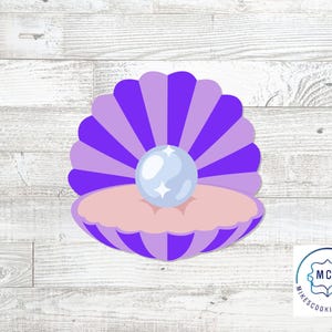 May include: A purple and pink seashell cookie cutter with a pearl in the center. The seashell has a fan-like design with alternating shades of purple. The pearl is light blue with four white star accents. The cookie cutter is on a white wooden background.