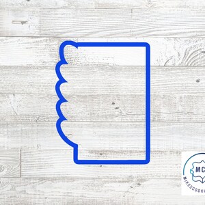 May include: Blue plastic cookie cutter shaped like a mug with a scalloped edge. The cookie cutter is on a white wood background.