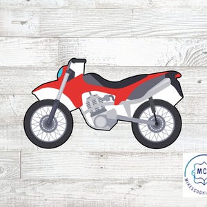 Op de afbeelding: Rode en grijze dirt bike koekjesvormer. De koekjesvormer is gevormd als een dirt bike met twee wielen, een zadel en een stuur.