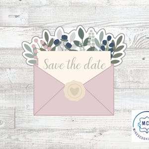 May include: A cookie cutter in the shape of a pink envelope with a floral arrangement on top. The envelope contains a card that reads "Save the date". A gold seal with a heart is on the envelope.
