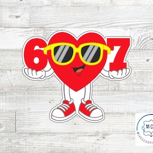May include: A red heart-shaped cartoon character wearing yellow sunglasses and red sneakers, holding the numbers 6 and 7. The character has a smiling face and white gloves. The image is a cookie cutter design.