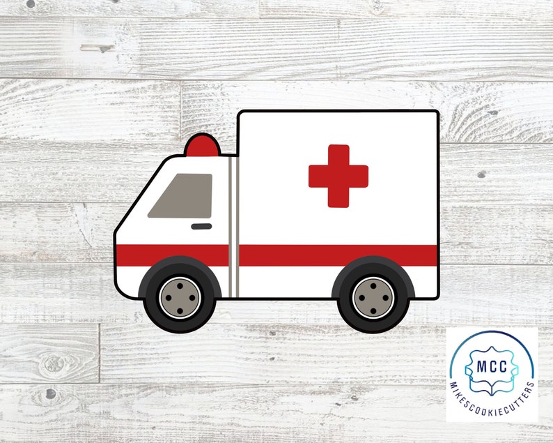 May include: A white ambulance cookie cutter with a red cross and red stripe. The cookie cutter is on a white wood background.