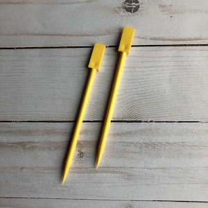 Peut inclure: Deux aiguilles à tricoter jaunes avec des pointes arrondies.