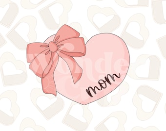 Könnte beinhalten: Ein rosa Herz mit einer rosa Schleife und dem Wort "mom" darin. Das Herz befindet sich auf einem weißen Hintergrund mit einem Muster aus kleineren rosa Herzen.
