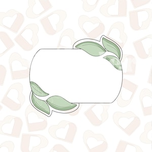 Peut inclure: Un cadre rectangulaire blanc avec un dessus et un bas arrondis, décoré de feuilles vertes de chaque côté. Le cadre est sur un fond blanc avec un motif de cœurs roses.