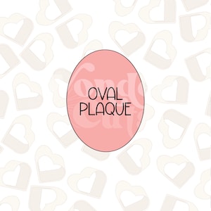 Peut inclure: Une plaque ovale rose avec le texte "OVAL PLAQUE" en lettres noires, sur un fond blanc avec un motif répétitif de cœurs blancs.