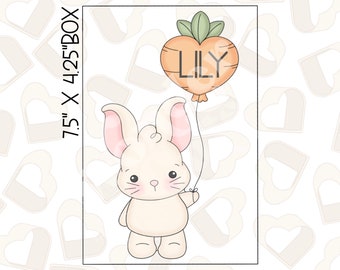 May include: A white bunny with pink ears holds a carrot-shaped balloon with the name "Lily" written on it. The image is 7.5 inches by 4.25 inches.