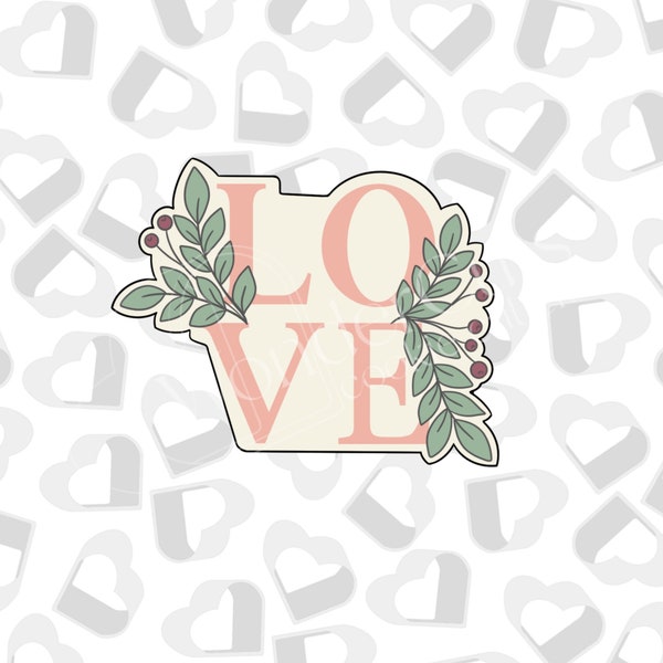 Placa con texto "Love" y cortador de galletas para San Valentín.