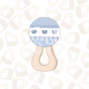 Puede incluir: Un sonajero para bebé azul y blanco con un mango. El sonajero tiene un borde de encaje blanco y tres pequeños corazones en la parte delantera.