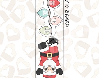 Puede incluir: Un conjunto de tres cortadores de galletas, uno con una figura de Papá Noel con un traje rojo y barba blanca, y los otros dos con una cadena de luces navideñas con cuatro bombillas de diferentes colores: rojo, rosa, verde y amarillo. El texto "3 X 10 BAG/BOX" está impreso en el lado derecho de la imagen.