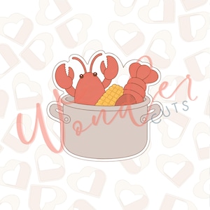 May include: A light grey cookie cutter shaped like a large cooking pot filled with a red lobster, a yellow ear of corn, and a red lobster tail. The design features a clean outline and a flat, solid surface, suitable for cutting dough shapes.