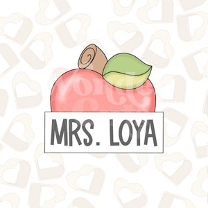 Puede incluir: Una manzana roja con una hoja verde y un tallo marrón. La manzana está sentada sobre una pancarta blanca con el texto "MRS. LOYA" en negro.