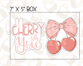 Könnte beinhalten: Ein rosa-weißes Design mit dem Text "I Cherry-sh You" und einem Paar Kirschen mit einer Schleife. Das Design befindet sich in einer 17,78 cm x 12,7 cm großen Box.