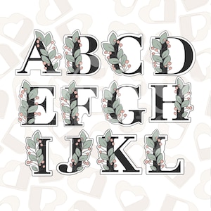 May include: A set of 12 cookie cutters in the shape of the letters A through L, each decorated with a leafy garland and pink berries. The cookie cutters are black and white.