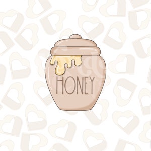 May include: A beige ceramic honey pot with a lid and a dripping honey design. The pot has the word "HONEY" written on the front.